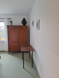Zimmer mit einem Holztisch und einem Schrank in der Unterkunft L'île Verte in Champagnac