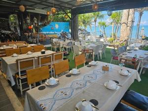 a restaurant with tables and chairs with a view of the ocean at Condo Centerviews Bangsaray Beach in Bang Sare