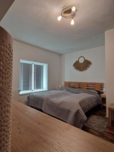 a bedroom with a large bed and a window at Haus Kampl - Appartement Ödensee in Obersdorf