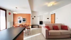 uma sala de estar e cozinha com um sofá e uma mesa em Rosso di Sera em Prata di Pordenone