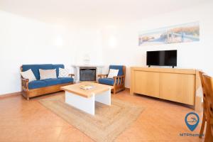 een woonkamer met een bank en een tv bij Casa Nico a 3 minutos da praia in Albufeira