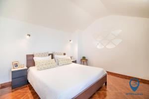 ein Schlafzimmer mit einem weißen Bett und einer weißen Decke in der Unterkunft Casa Nico a 3 minutos da praia in Albufeira
