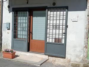 una entrada a un edificio con dos puertas y una maceta de flores en LA CASA DI SIRA, en Veiano