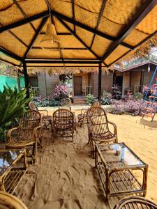 a group of chairs and tables under an umbrella at Pousada Donaciana - Beach Cottages in Baga