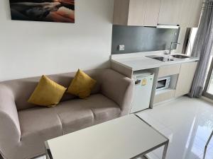 a small living room with a couch and a kitchen at Arcadia Beach Resort Condominium in Pattaya South