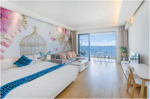 een slaapkamer met een bed en een kamer met uitzicht op de oceaan bij Xiaojing Bay Haige Hotel in Pingshan
