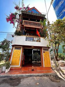 ein Gebäude mit gelben Türen an der Seite in der Unterkunft Biệt thự gỗ Wooden House Quy Nhơn cạnh biển in Quy Nhon
