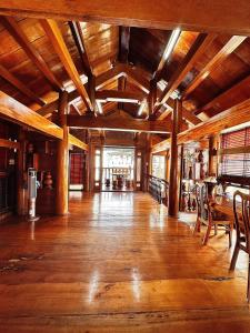 歸仁的住宿－Biệt thự gỗ Wooden House Quy Nhơn cạnh biển，大型客房铺有木地板,配有桌椅。