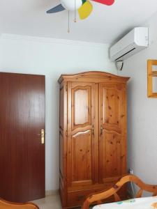 a bedroom with a wooden cabinet and a ceiling fan at Miramar in Mazagón +10 photos