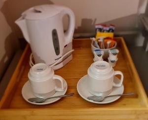 a table with two cups and a coffee pot and spoons at Superior Hotel in Dudley