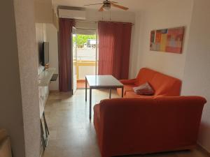 a living room with a red couch and a table at Miramar in Mazagón