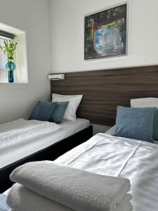 a bedroom with two beds and a vase on the wall at ApartHotel Faber in Aarhus