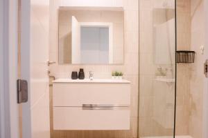 a white bathroom with a sink and a mirror at Apartamento Pemedal in Villaverde +49 photos