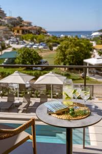 a table with wine glasses and a laptop on a balcony at Sofibel sivota suites in Sivota