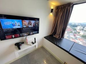 a room with a large window and a flat screen tv at IMPERIO BY MICASA in Melaka