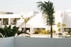 a white building with palm trees in front of it at Apartamento Pemedal in Villaverde