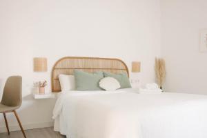 a bedroom with a white bed with a wooden headboard at Apartamento Pemedal in Villaverde