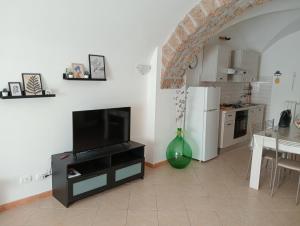 a living room with a television and a kitchen at LA CASA DI SIRA in Veiano