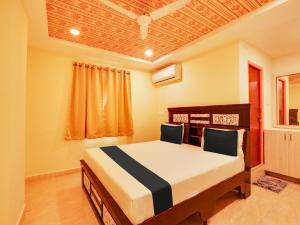 a bedroom with a bed with two chairs in it at Super OYO Flagship Hotel Bommarillu in Warangal