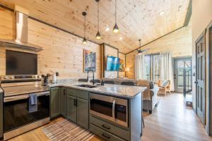 a kitchen with a sink and a stove in a room at Hot Tub, Games, Fireplace & Fast WiFi Near Dollywood in Sevierville