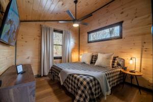 a bedroom with a bed in a wooden cabin at Hot Tub, Games, Fireplace & Fast WiFi Near Dollywood in Sevierville