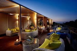 a deck with couches and chairs on a balcony at Rodos Park in Rhodes Town