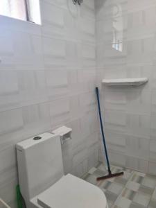 a white bathroom with a toilet and a mop at Home Stay Boutique Zanzibar in Stone Town