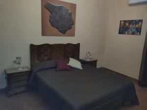 a bedroom with a bed and a picture on the wall at casa vacanze da Mary in Campobello di Licata