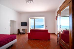a bedroom with a red couch and a view of the ocean at Donna Giulia in Amalfi