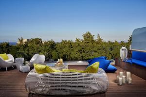 a patio with a white wicker couch and a table at Rodos Park in Rhodes Town
