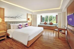 a bedroom with a large white bed and a couch at FOX Hotel Jimbaran Beach in Jimbaran