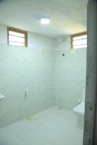 Baño blanco con lavabo y aseo en Flamingo Resort, en Mannar