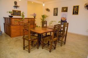 a dining room with a wooden table and chairs at Lily Resort Udawalawe in Udawalawe