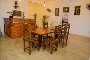 Lily Resort Udawalawe في اوداوالاوي: غرفة طعام مع طاولة وكراسي خشبية