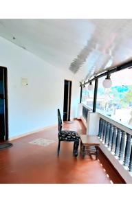 a room with a chair and a table and a balcony at SNS Beach Side Stay CALANGUTE in Calangute
