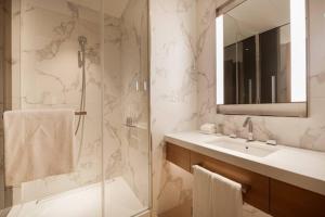 a bathroom with a shower and a sink and a mirror at Luxurious stay in Downtown Dubai in Dubai