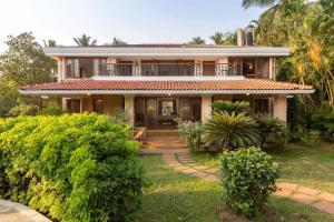 a house with a pathway leading to the front yard at Theta Villa in Alibag