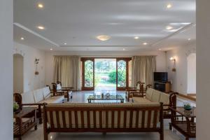 a large living room with a table and chairs at Theta Villa in Alibag