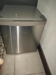 a metal refrigerator in a corner of a room at Van Dyk guest house in Boksburg