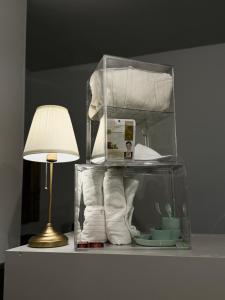 uma caixa de vidro com toalhas e um candeeiro sobre uma mesa em NAP v em Valência