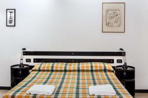 a bedroom with a bed with two towels on it at Hotel Cairoli in Genova