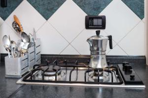 a kitchen counter with a coffee maker on a stove at Hotel Cairoli in Genoa