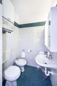 a white bathroom with a toilet and a sink at Hotel Cairoli in Genova