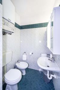 een witte badkamer met een toilet en een wastafel bij Hotel Cairoli in Genua