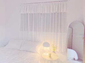 a bedroom with a white bed and a table with a lamp at 2Room Jamsil lotteworld Kspo dome Olympic Park 2Queenbed in Seoul