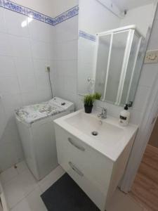 een witte badkamer met een wastafel en een spiegel bij Apartamento San Antón in Huesca