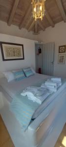 a bedroom with a white bed with a chandelier at Simos suites in Elafonisos