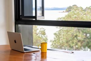 派西亞的住宿－群島灣（派西亞）哈卡山林小屋旅舍，坐在窗边桌子上的笔记本电脑
