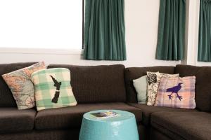 派西亞的住宿－群島灣（派西亞）哈卡山林小屋旅舍，客厅配有棕色沙发和绿色窗帘