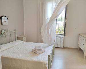 a white bedroom with a bed with two towels on it at Villa Contessina in Cossignano +72 photos